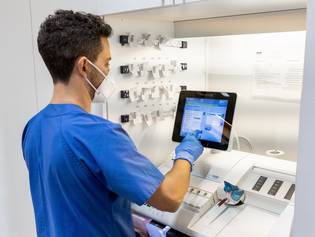 Ein Pfleger bedient ein medizinisches Gerät über ein Touch-Display 